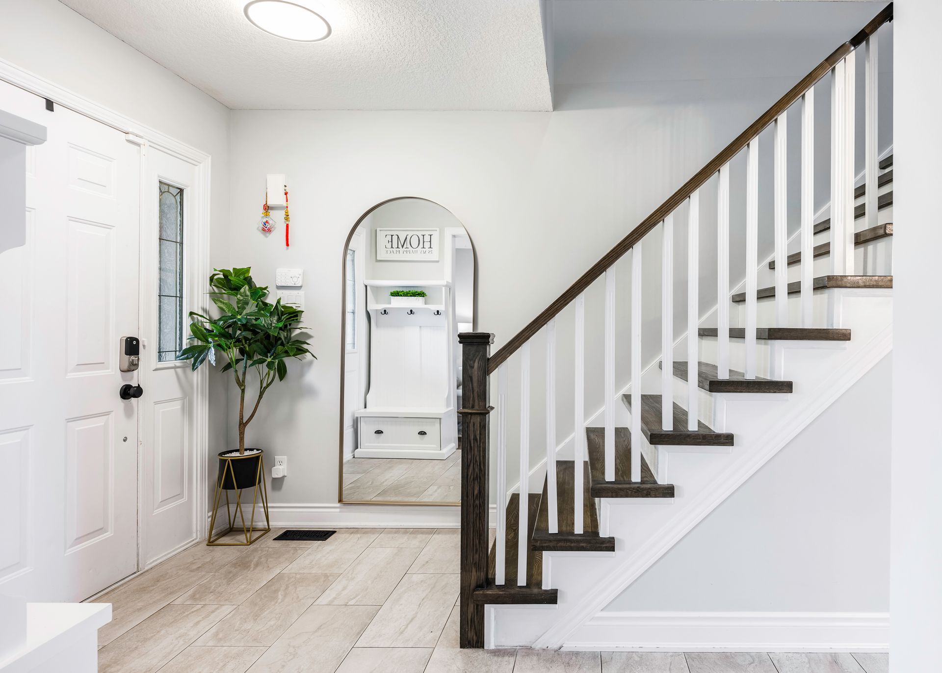 A hallway with stairs leading up to the second floor of a house.