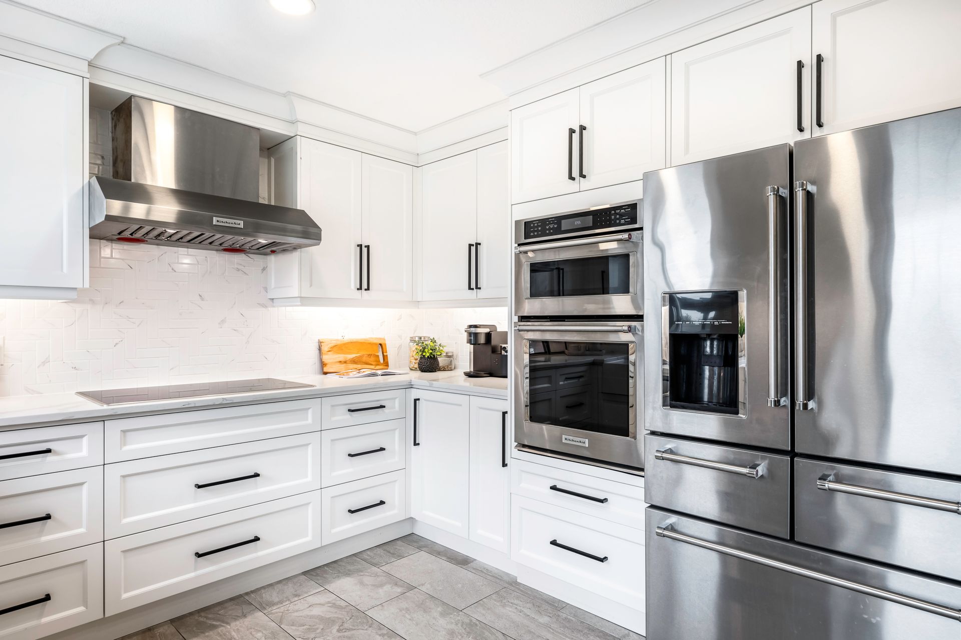 A kitchen with white cabinets and stainless steel appliances.