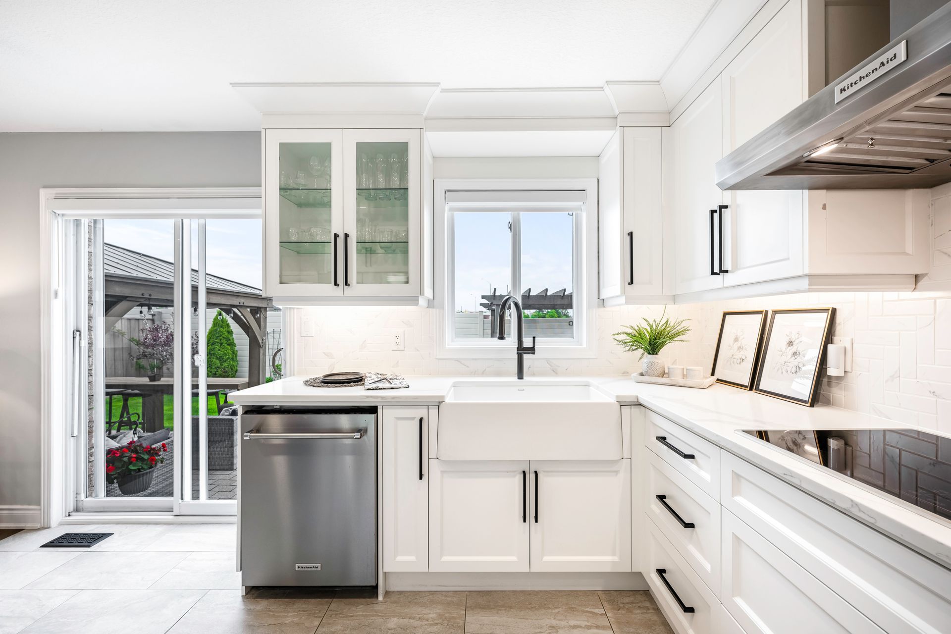 A kitchen with white cabinets , stainless steel appliances , a sink and a stove.