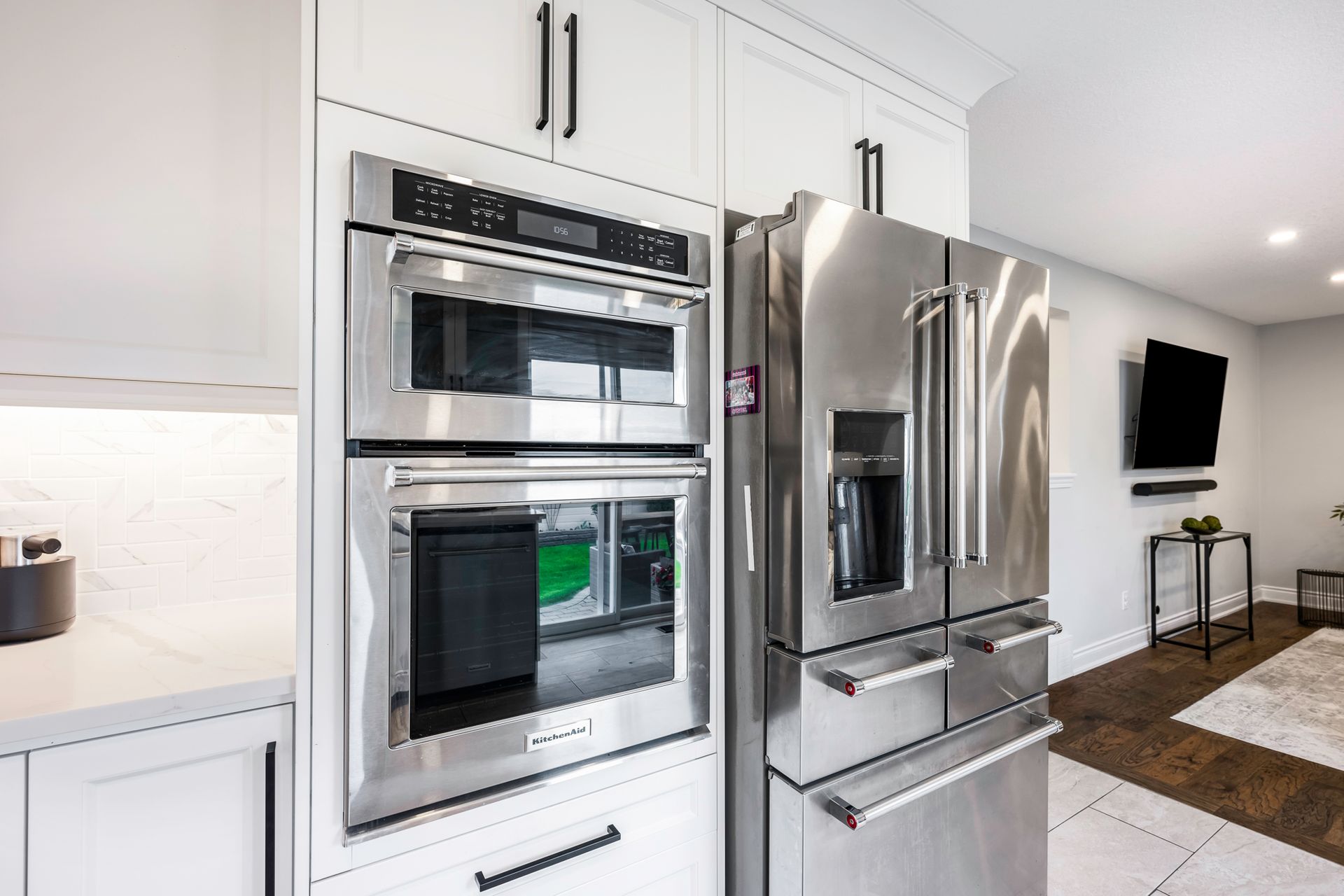 A kitchen with stainless steel appliances and white cabinets.