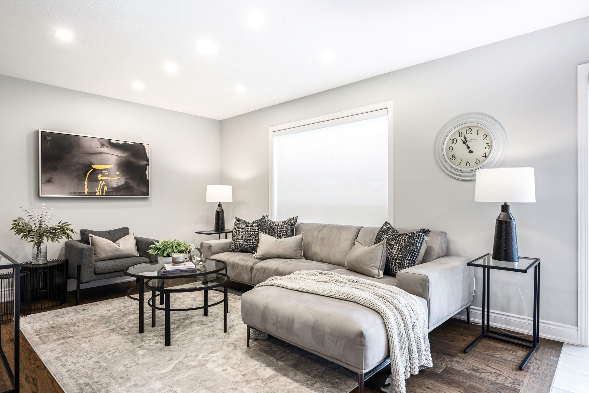 A living room filled with furniture and a clock on the wall.