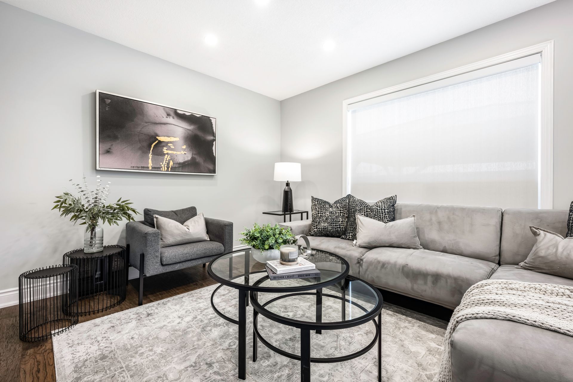 A living room with a couch , chairs , and two coffee tables.
