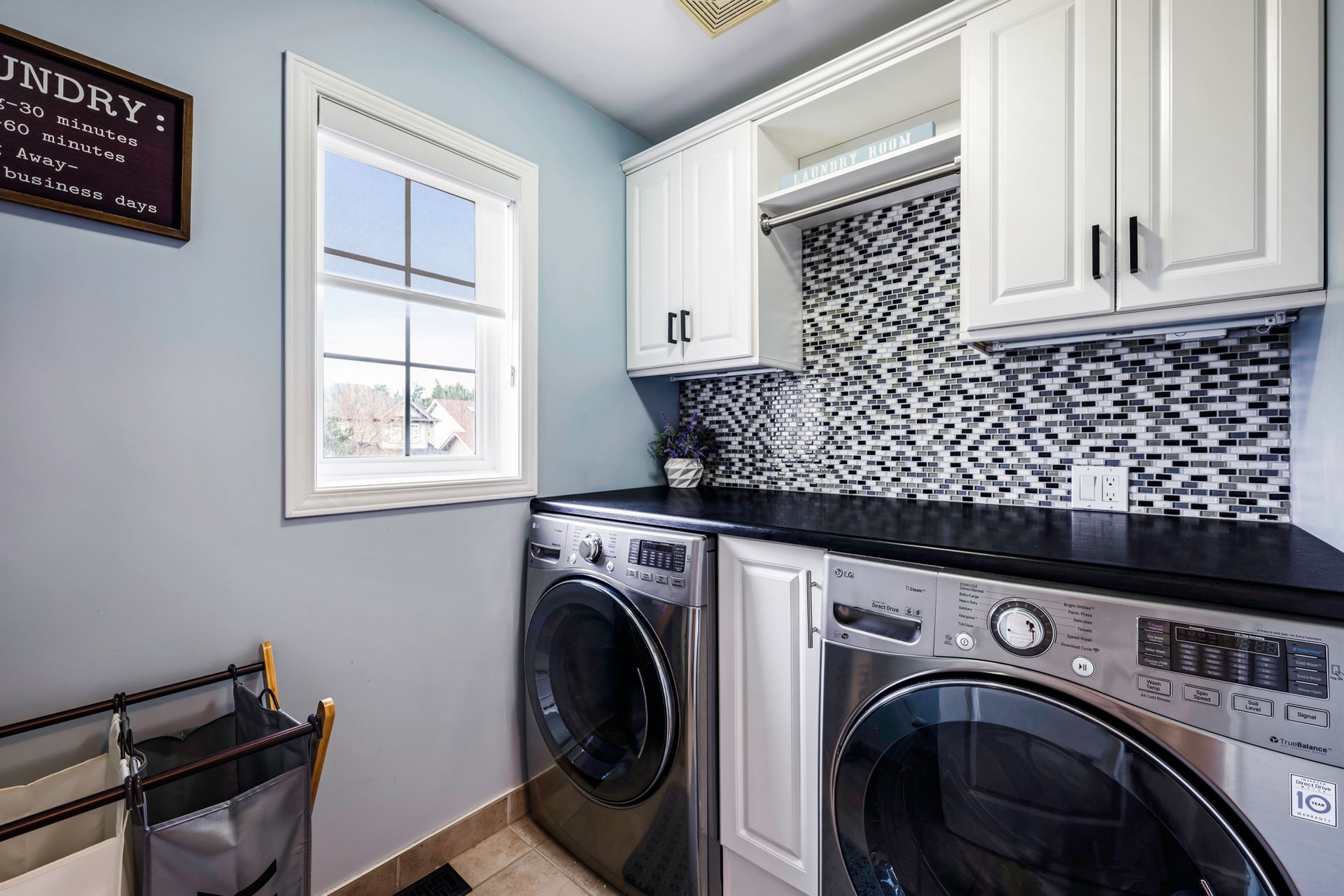 A laundry room with a washer and dryer and a window.