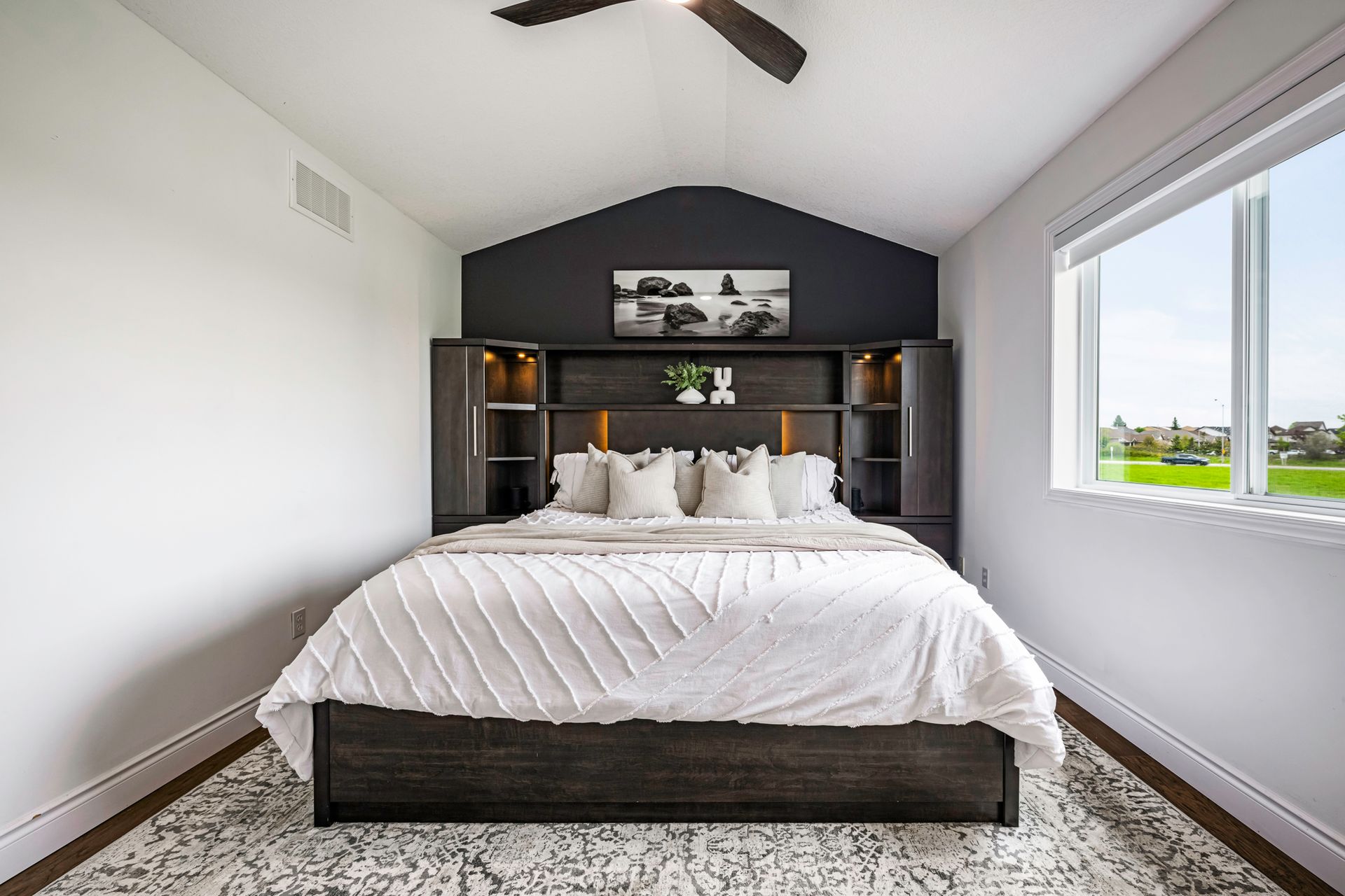 A bedroom with a large bed and a ceiling fan.