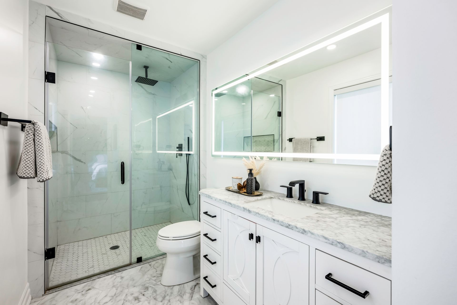 A bathroom with a toilet , sink , shower and mirror.
