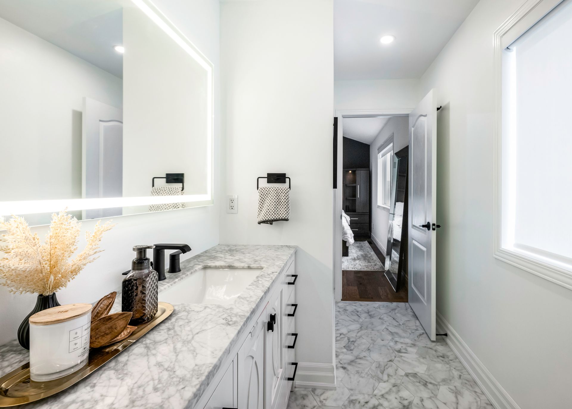 A bathroom with a sink , mirror and marble floor.