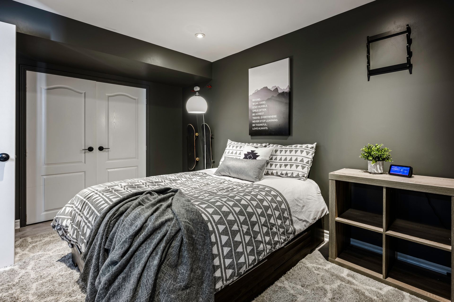 A bedroom with a bed , dresser , and a clock on the wall.