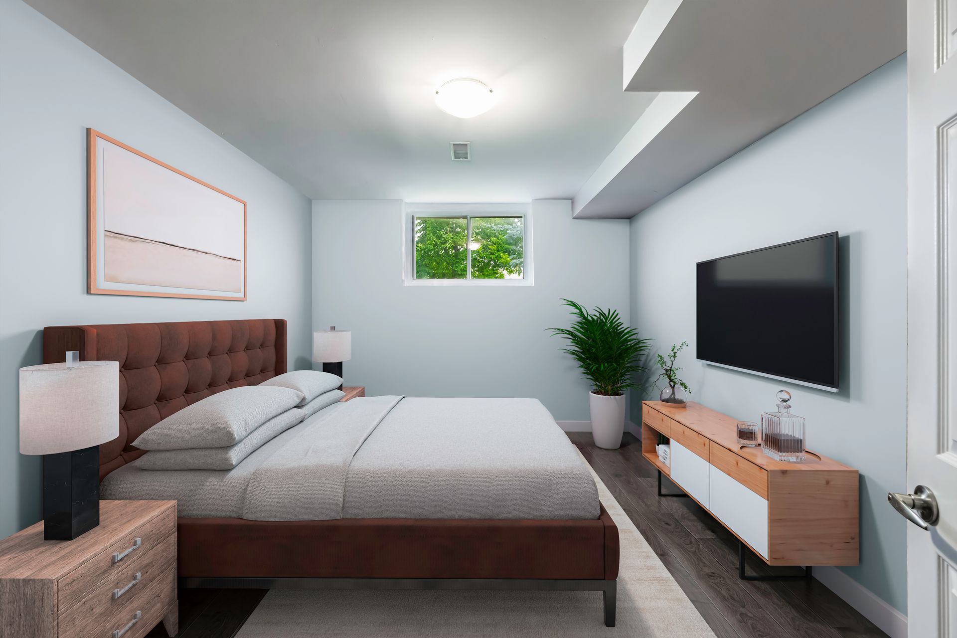 A bedroom with a large bed and a flat screen tv on the wall.