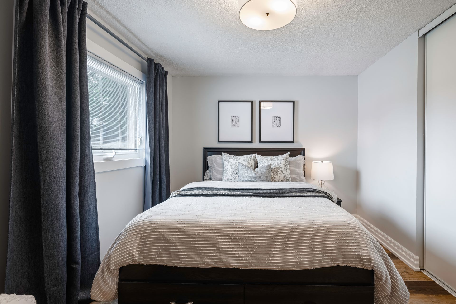 A bedroom with a bed , curtains and a window.