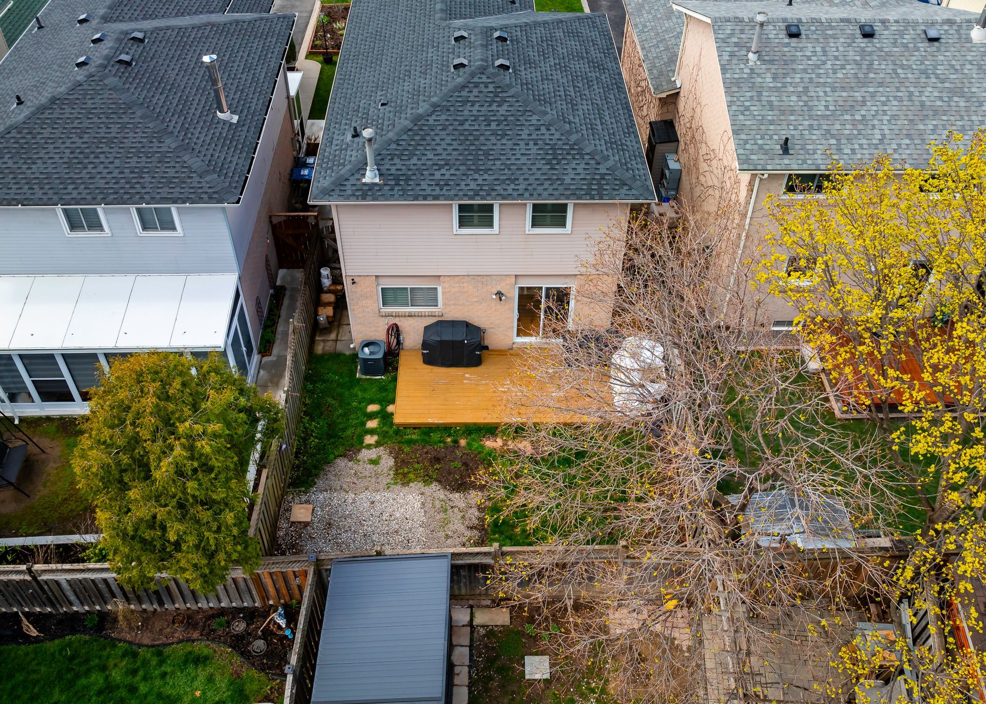 An aerial view of a house with a deck in the backyard.