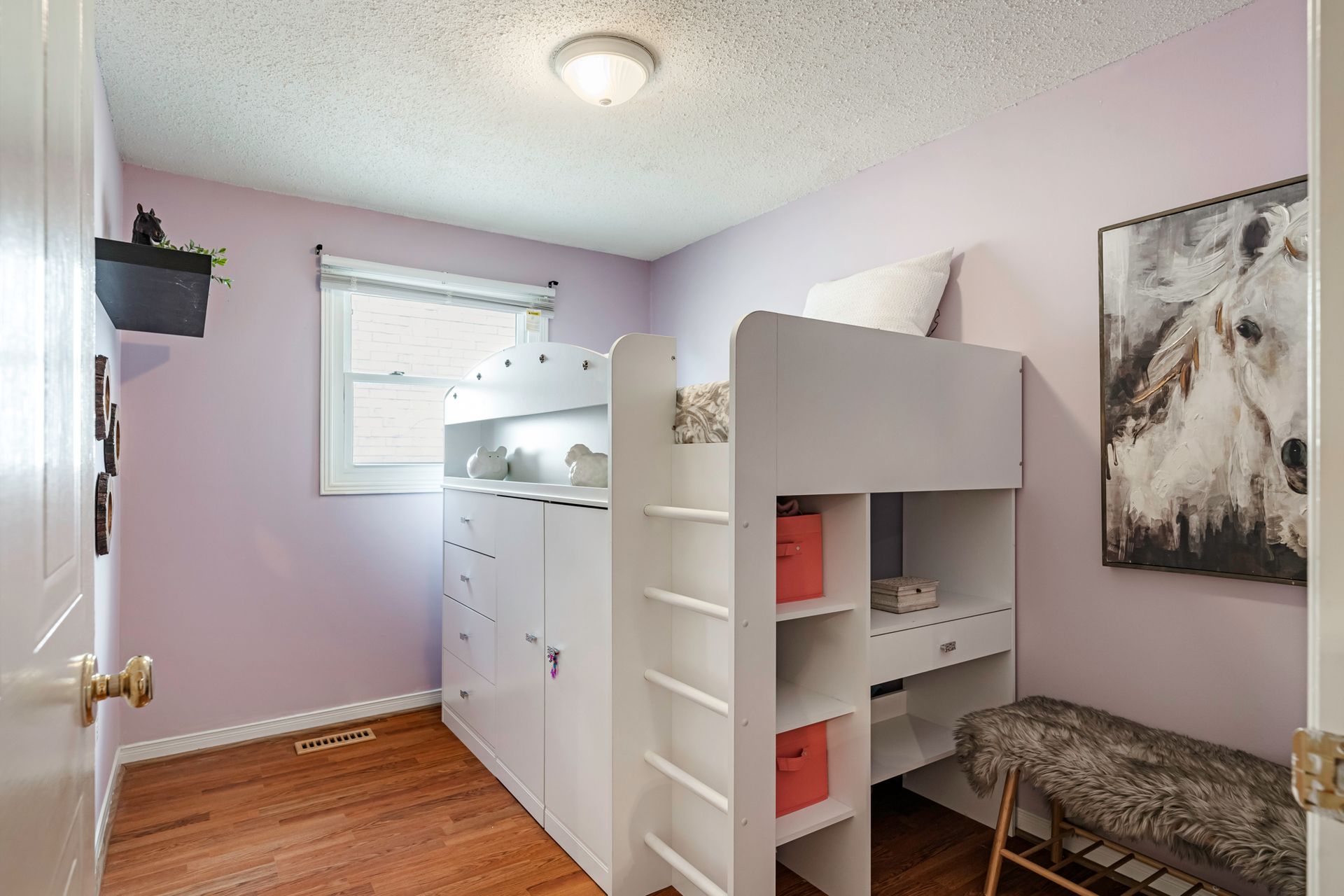 A bedroom with a bunk bed and a painting on the wall.