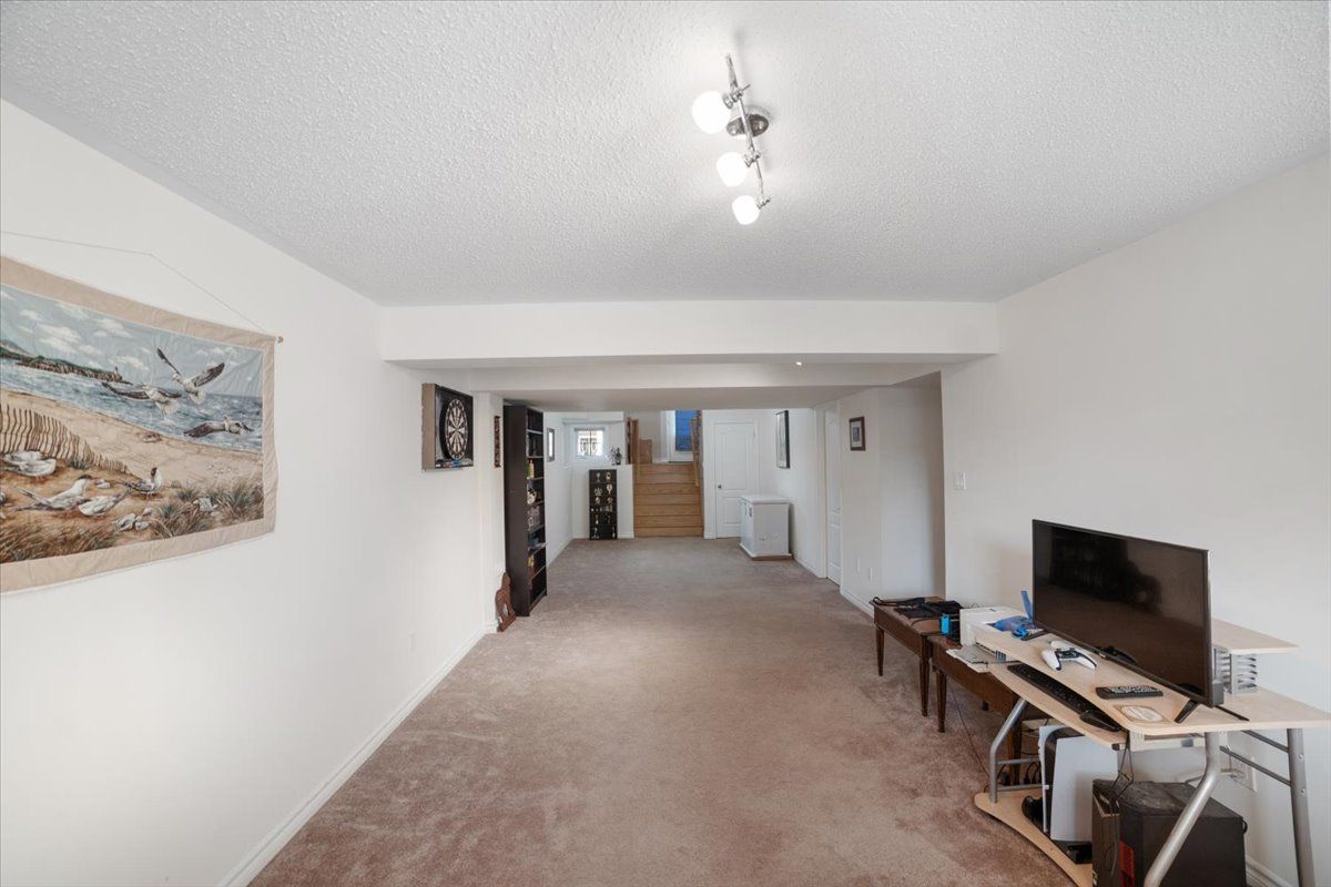 A living room with a flat screen tv and a painting on the wall.