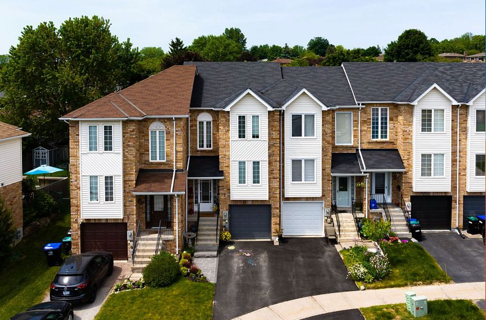 A row of houses with cars parked in front of them
