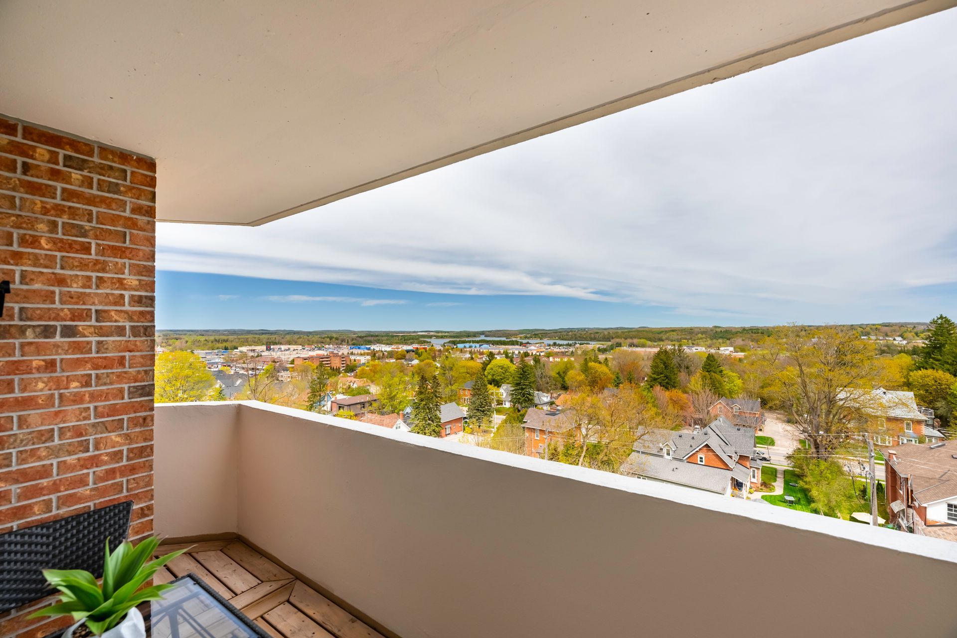 A balcony with a view of a city and trees.