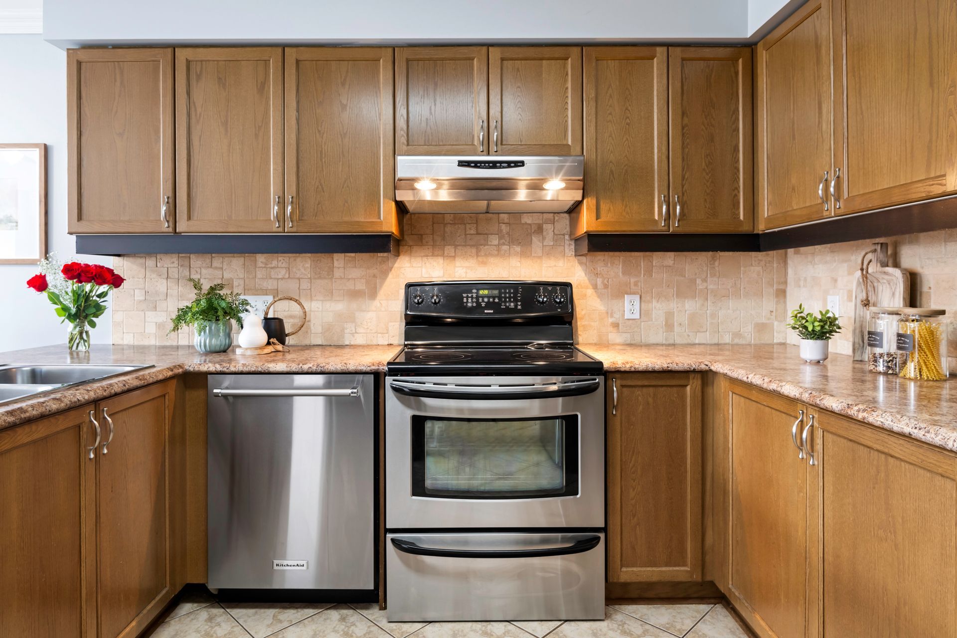 A kitchen with stainless steel appliances and wooden cabinets.