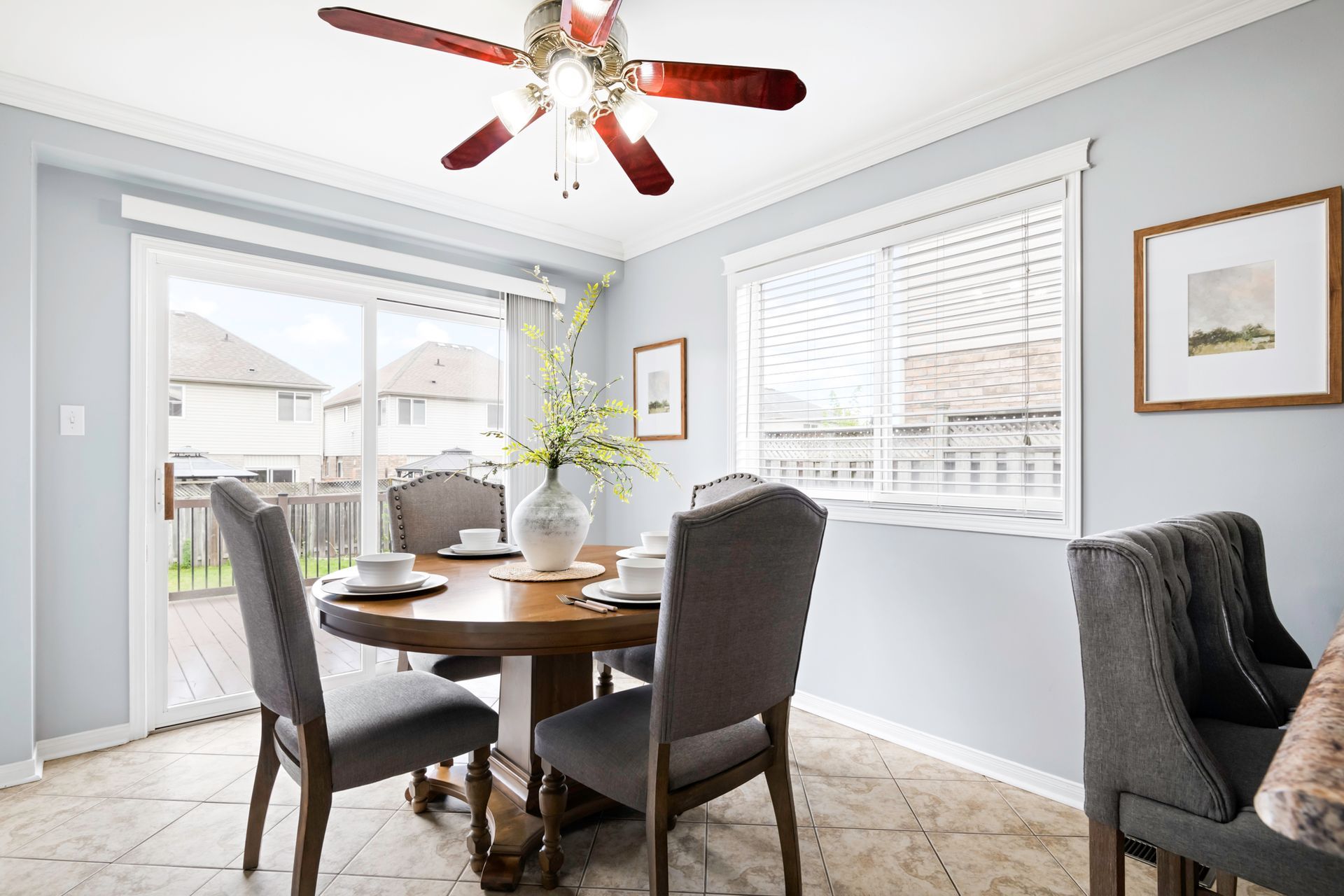 A dining room with a table and chairs and a ceiling fan.