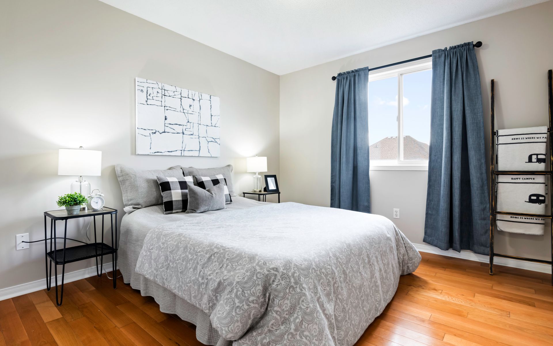 A bedroom with a bed , nightstand , ladder and window.