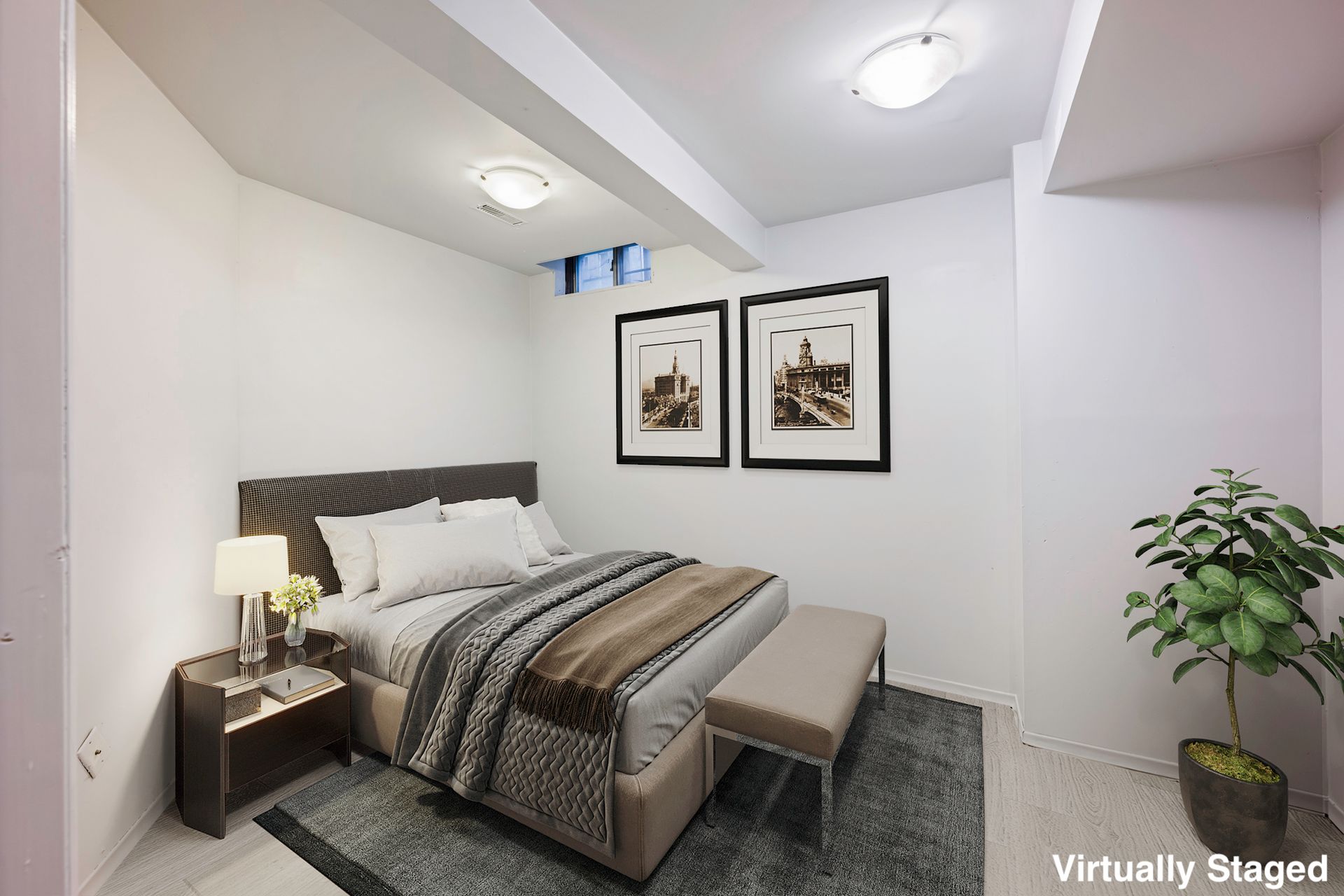 A bedroom with a large bed and two pictures on the wall