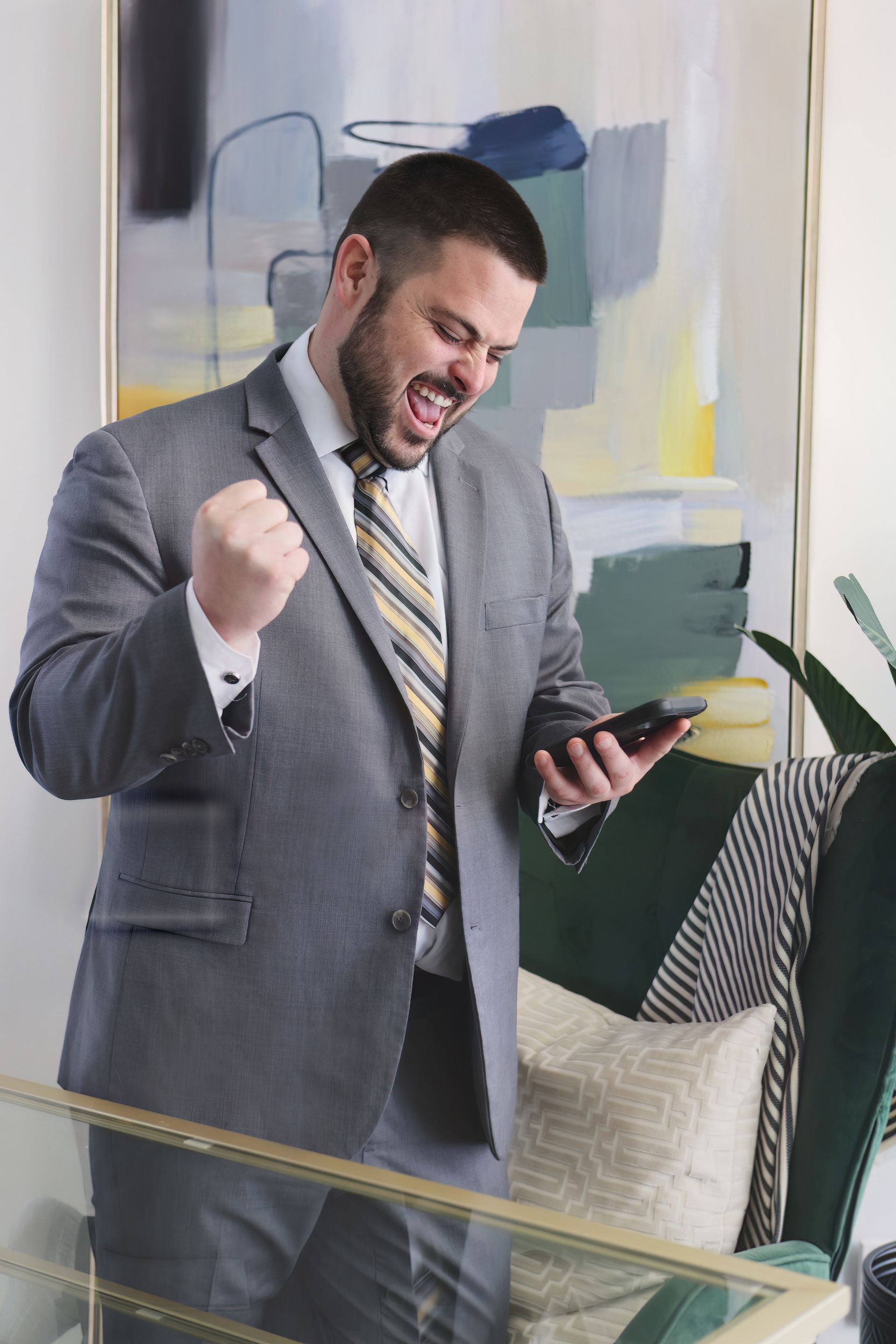 A man in a suit and tie is holding a cell phone.