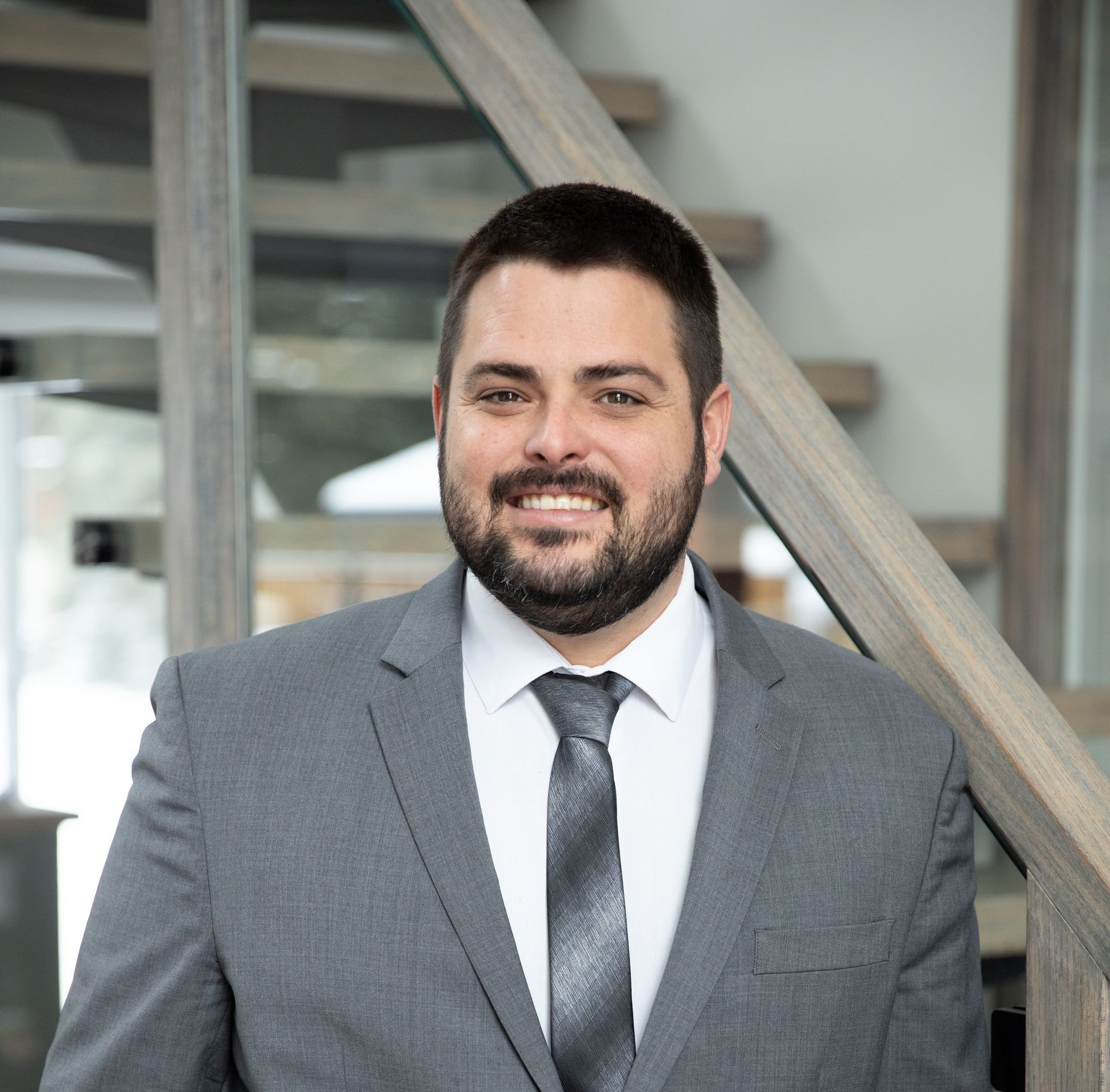 A man in a suit and tie is standing in front of a set of stairs.