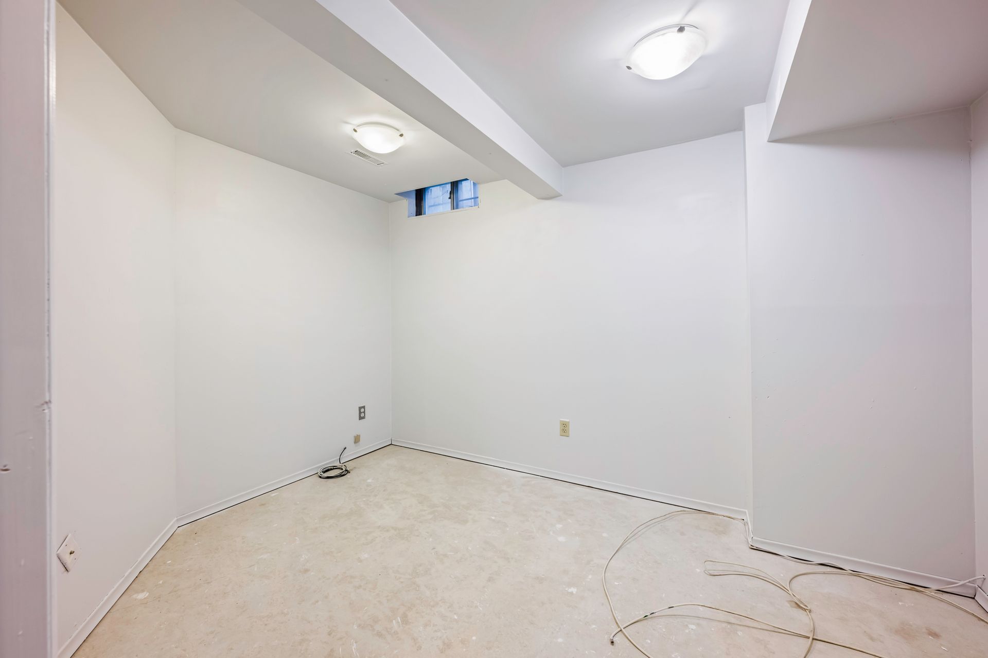 An empty room with white walls and a white carpet.