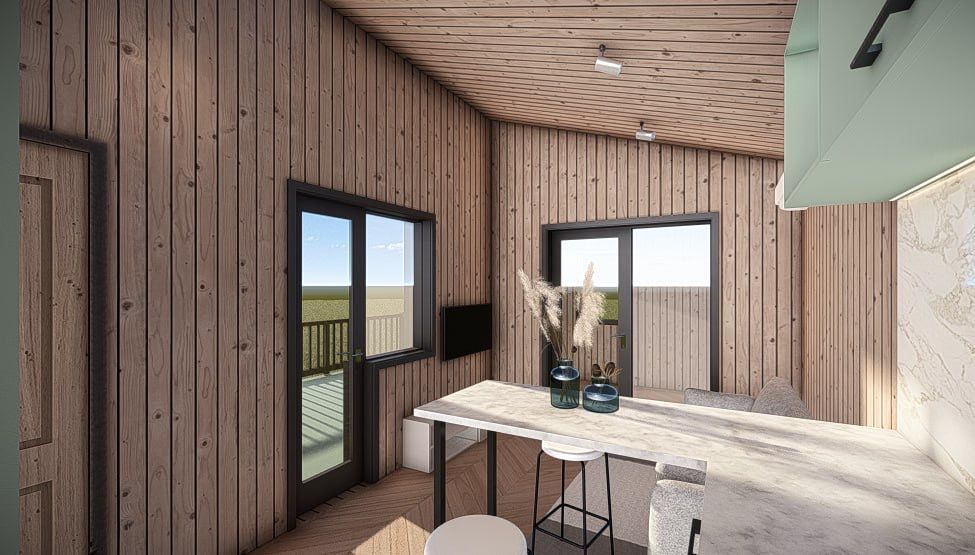 Interior view of a wooden cabin kitchen with windows, a counter, and a ceiling fan.