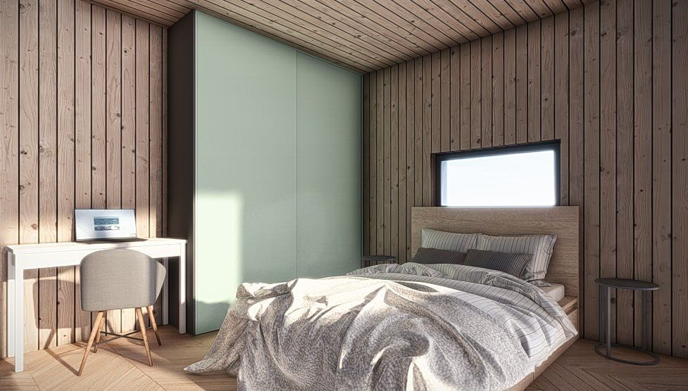 Bedroom interior with wooden walls and bed, desk with laptop, and a large wardrobe.