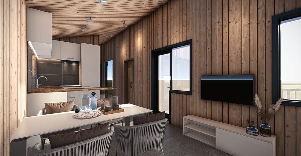 Interior of a modern cabin with wood panel walls, a white kitchen, and dining area. TV on wall.