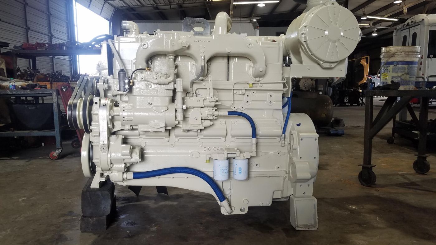 Large white industrial engine with blue hoses in a workshop, viewed from the side | S&V Diesel Repair