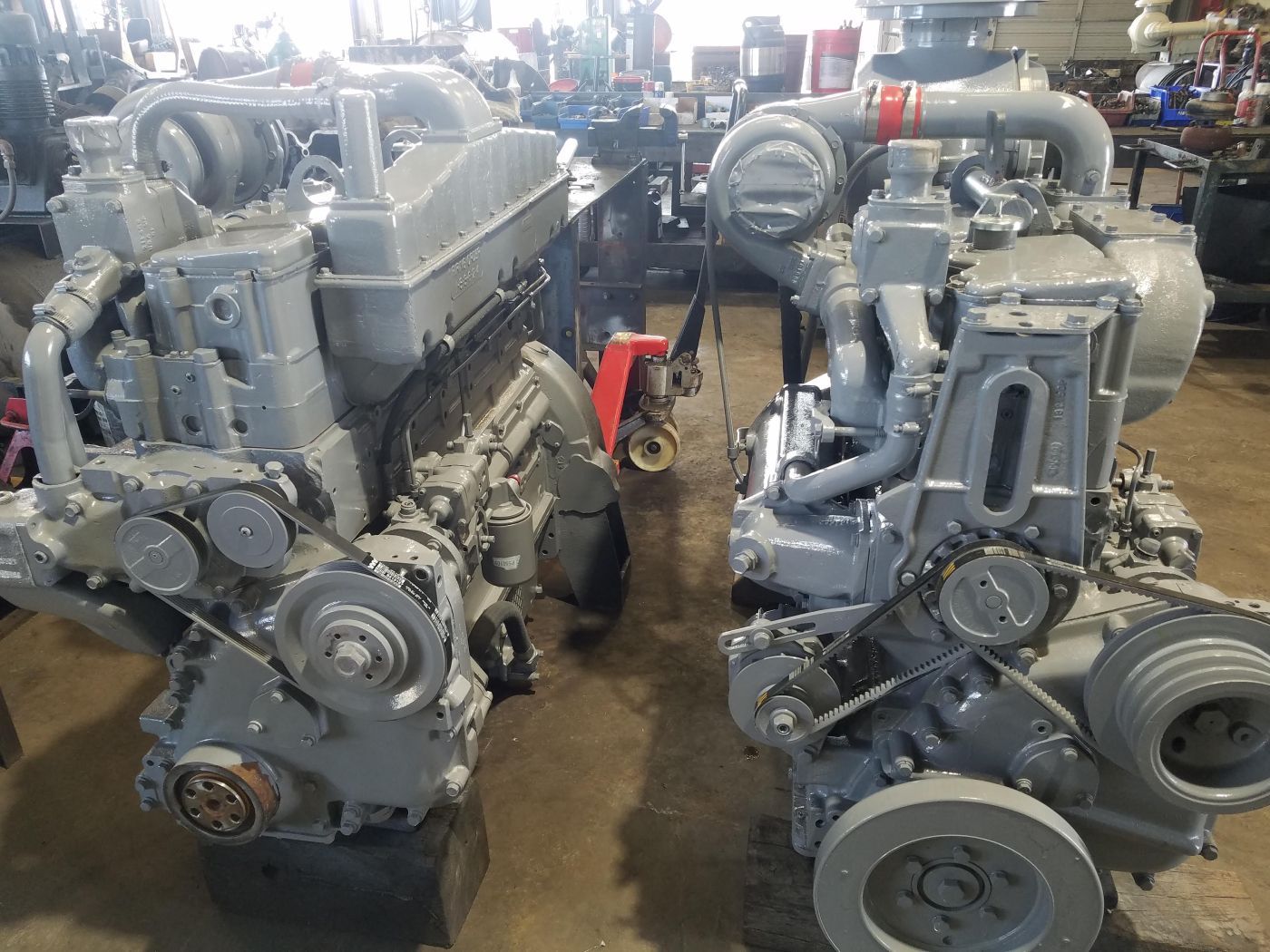 Two large gray industrial engines on a workshop floor, shown side by side. | S&V Diesel Repair