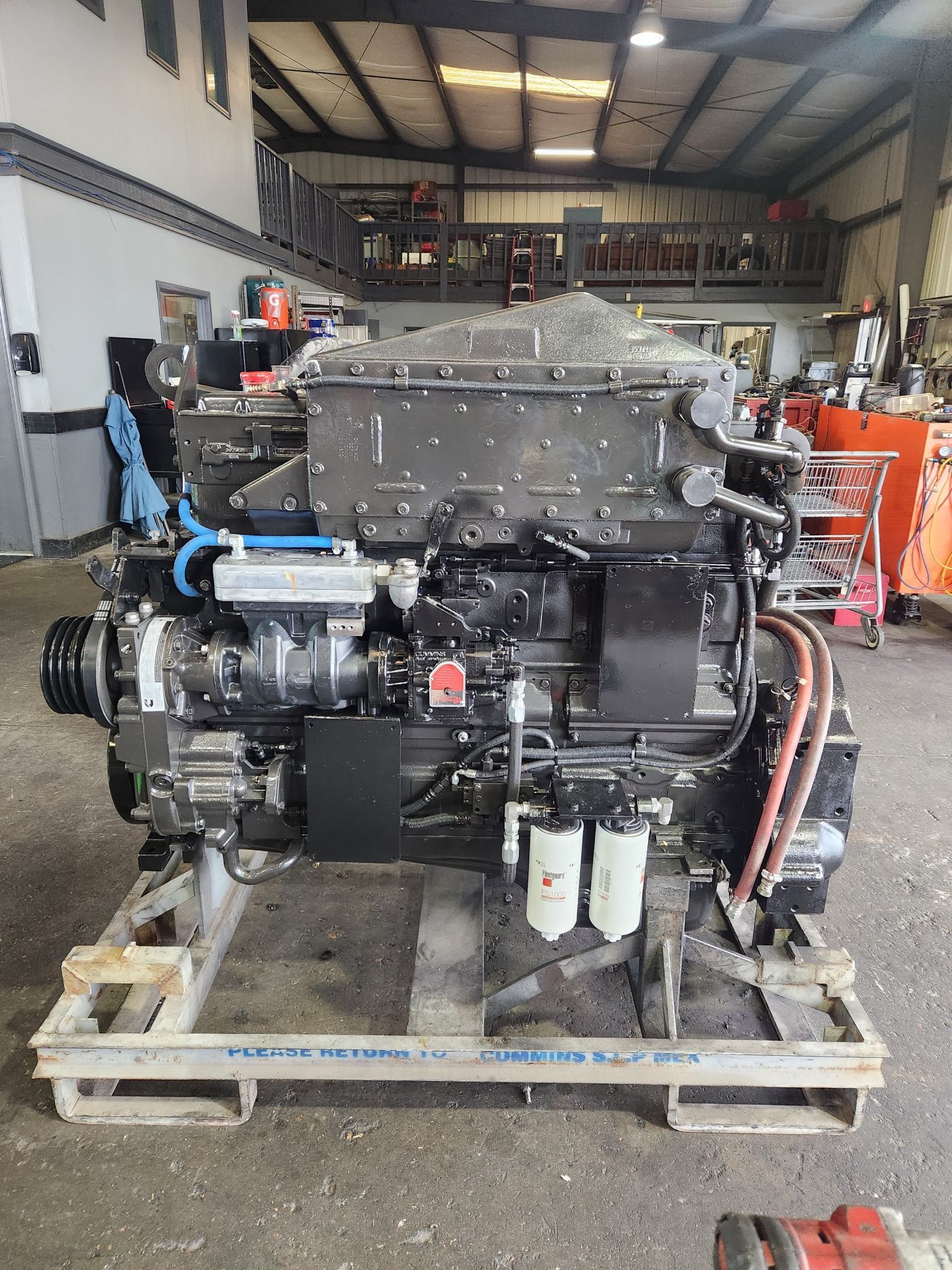 Large black industrial engine on a wooden pallet in a workshop garage | S&V Diesel Repair