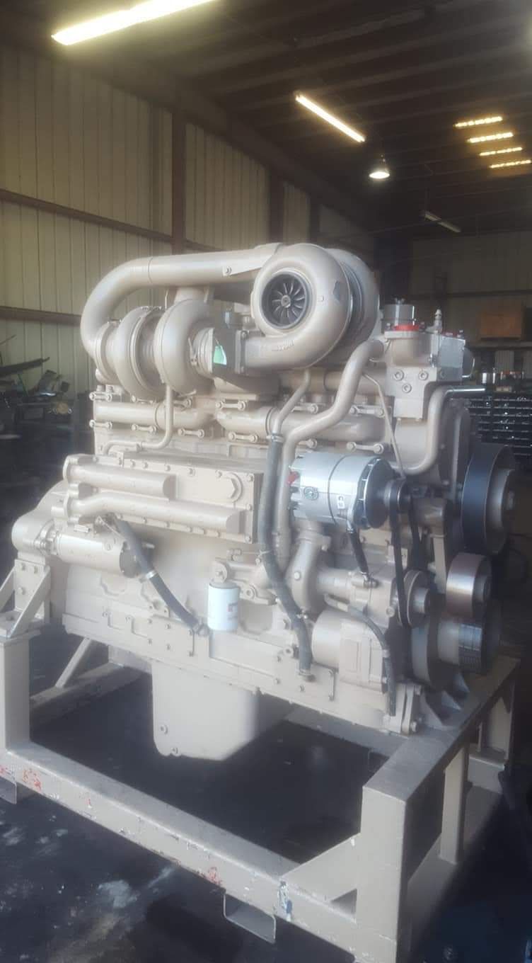 Large white industrial engine mounted on a metal frame inside a warehouse. | S&V Diesel Repair