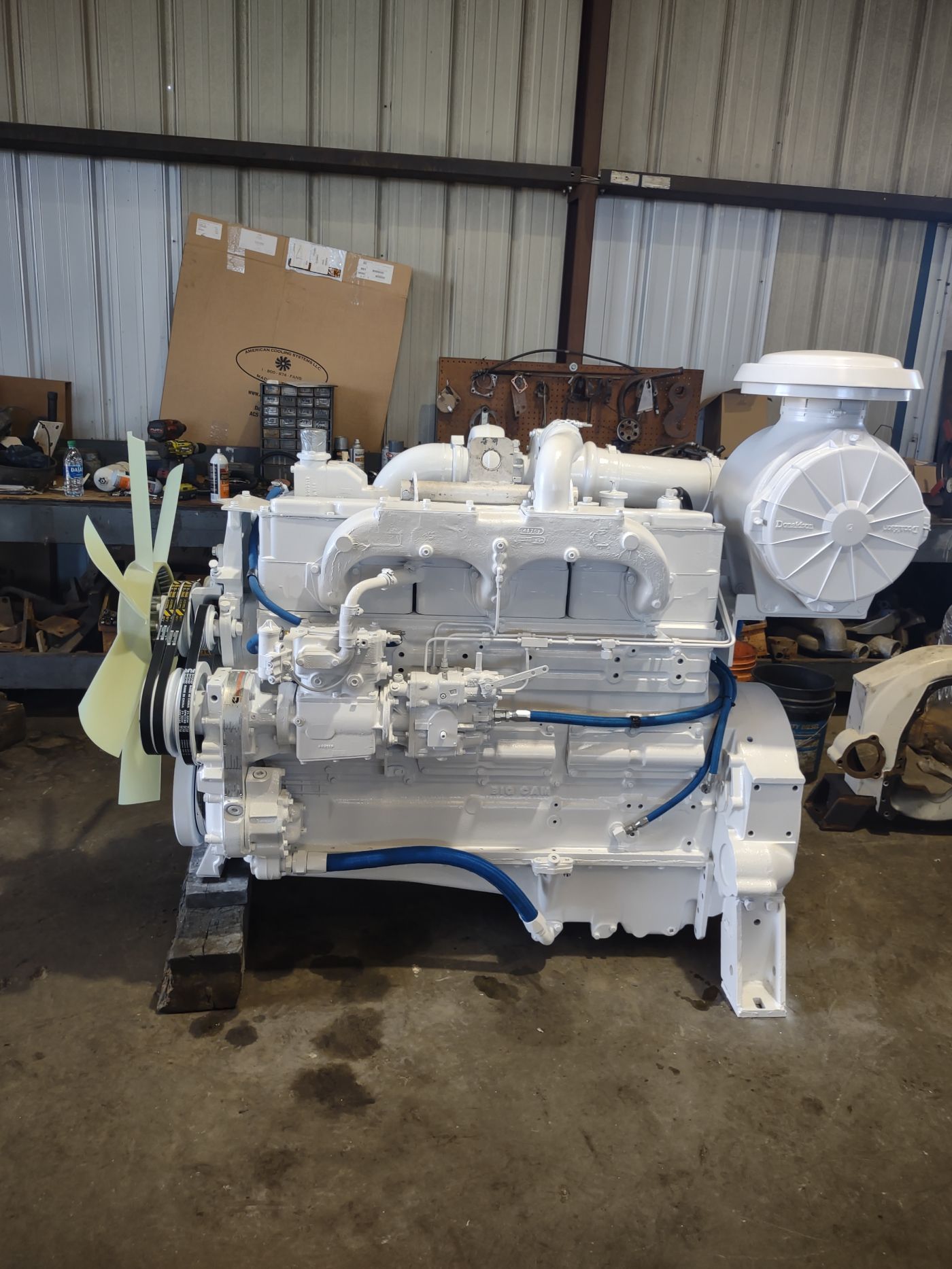 White industrial engine or generator on pallets inside a warehouse workshop | S&V Diesel Repair