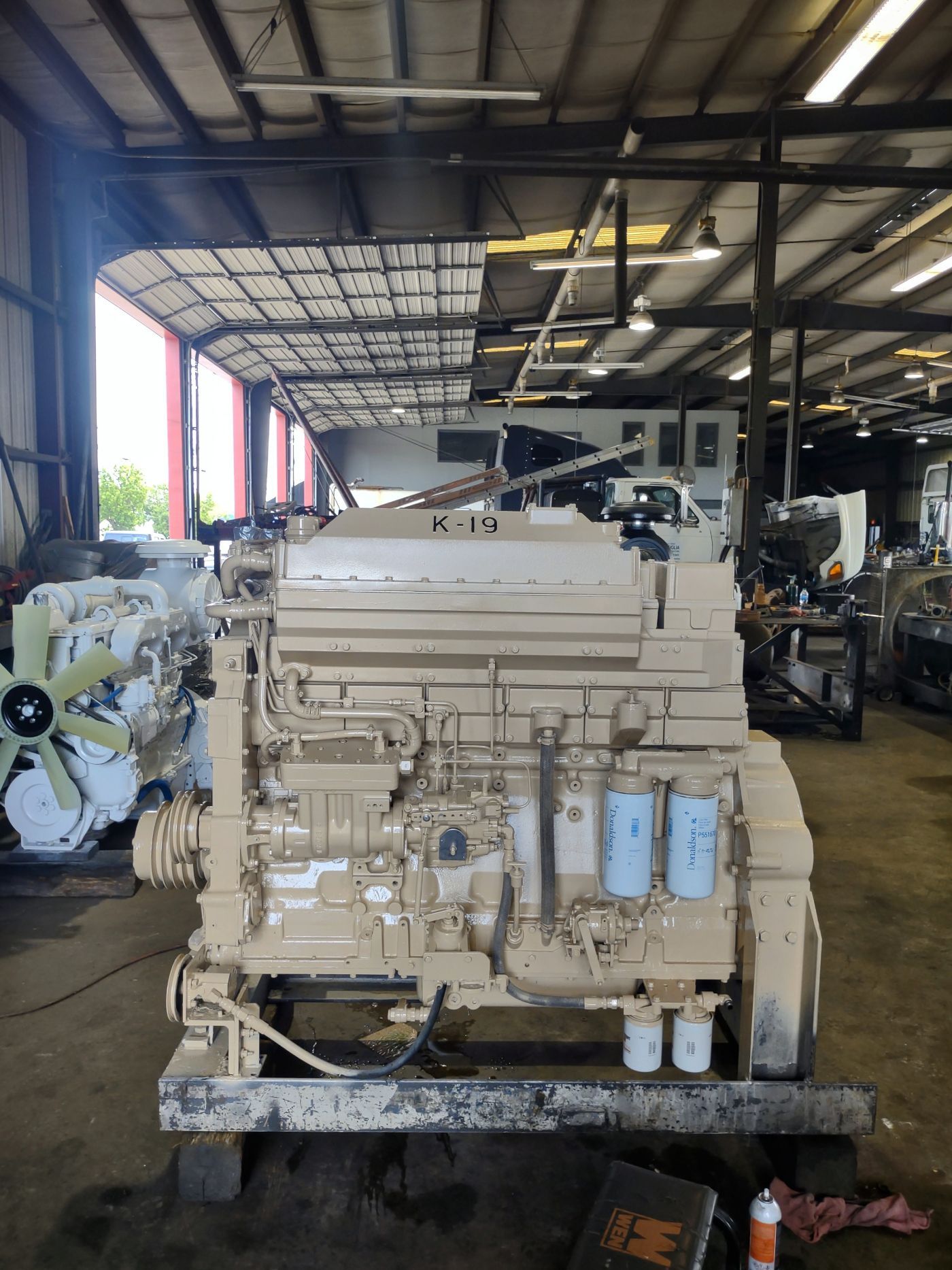 Large industrial engine on a pallet in a warehouse workshop, with other machinery in the background | S&V Diesel Repair