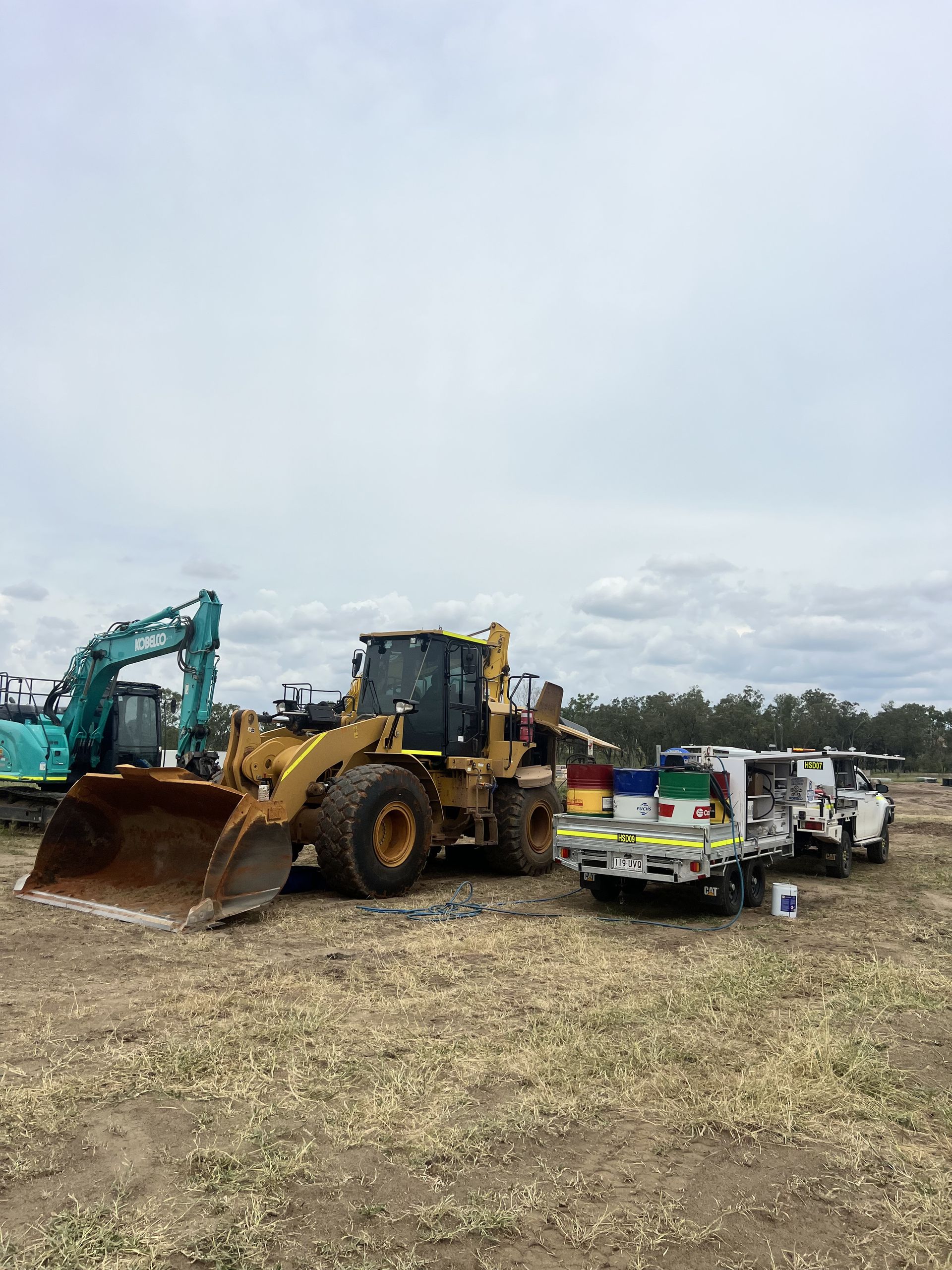 Yellow and Black Loader, Green Excavator, and Two White Work Trucks — HOLESHOT Diesel In Brisbane, QLD