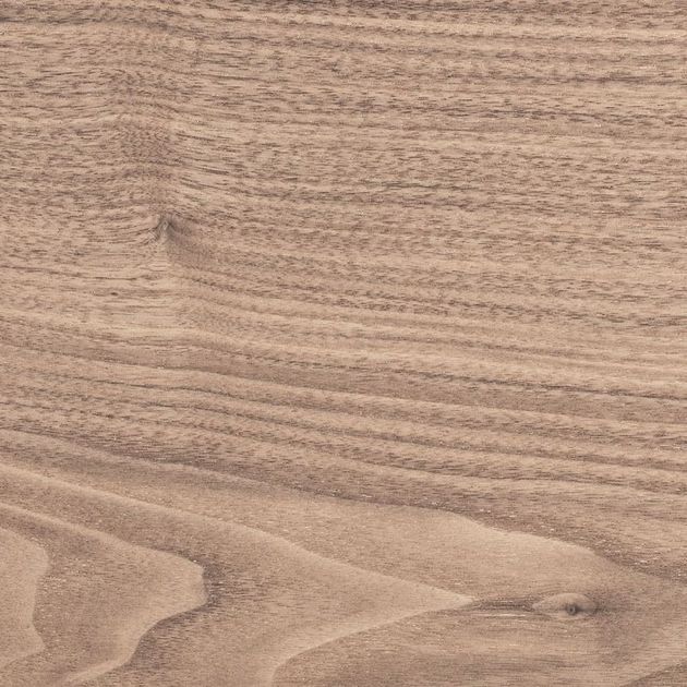 Primo piano di una superficie in legno marrone chiaro, con linee curve e strutturate.