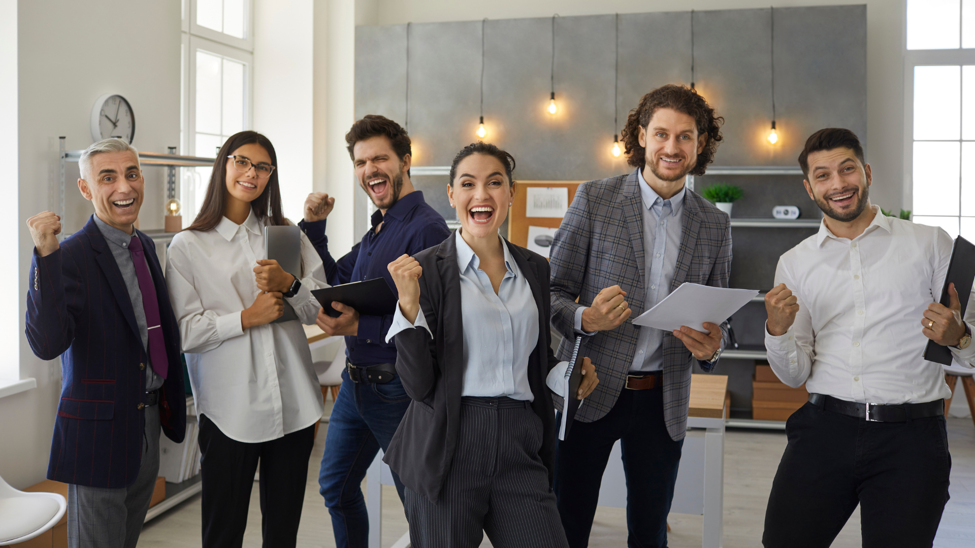 A team of corporate team members celebrating wins and acknowledging team breakthroughs.
