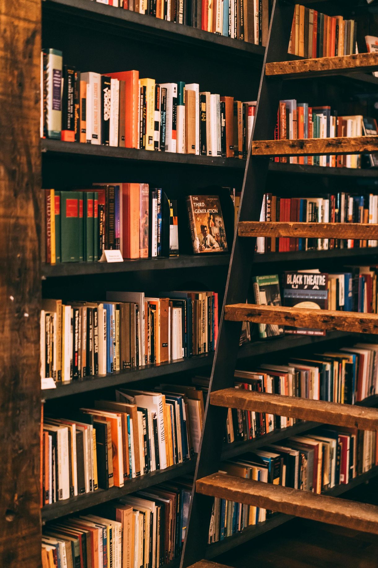 A library filled with lots of books and a ladder.