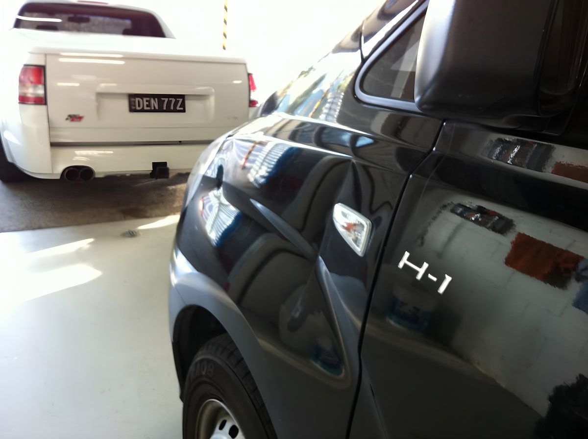 A Black H-1 Truck is Parked Next to a White Truck — Rapid Auto Dent In The Entrance, NSW