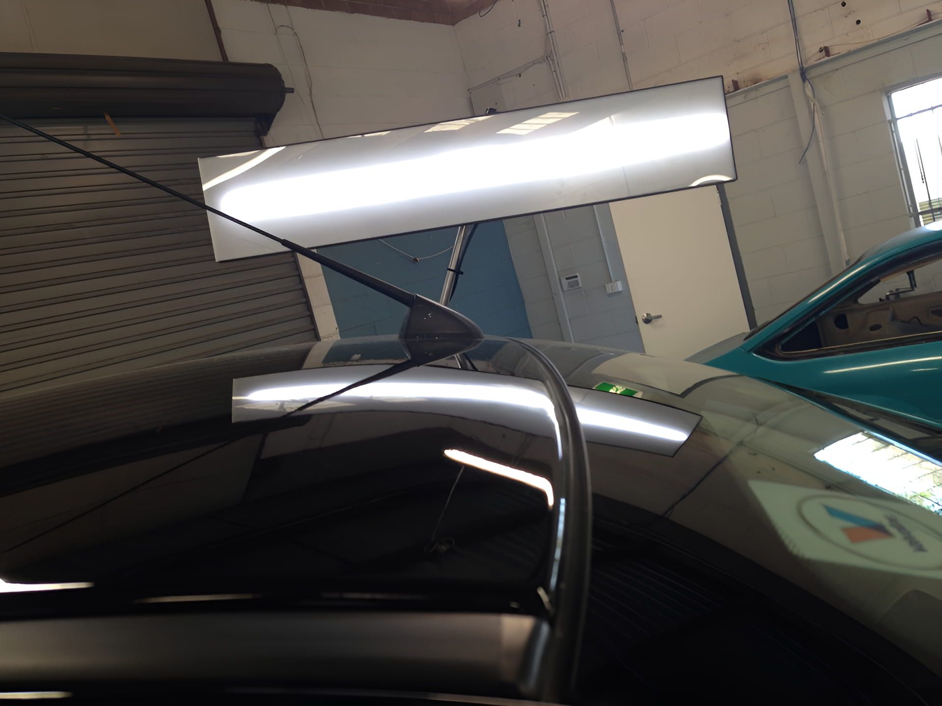 A Blue Car Is Parked Next To A Black Car In A Garage — Rapid Auto Dent In West Gosford, NSW