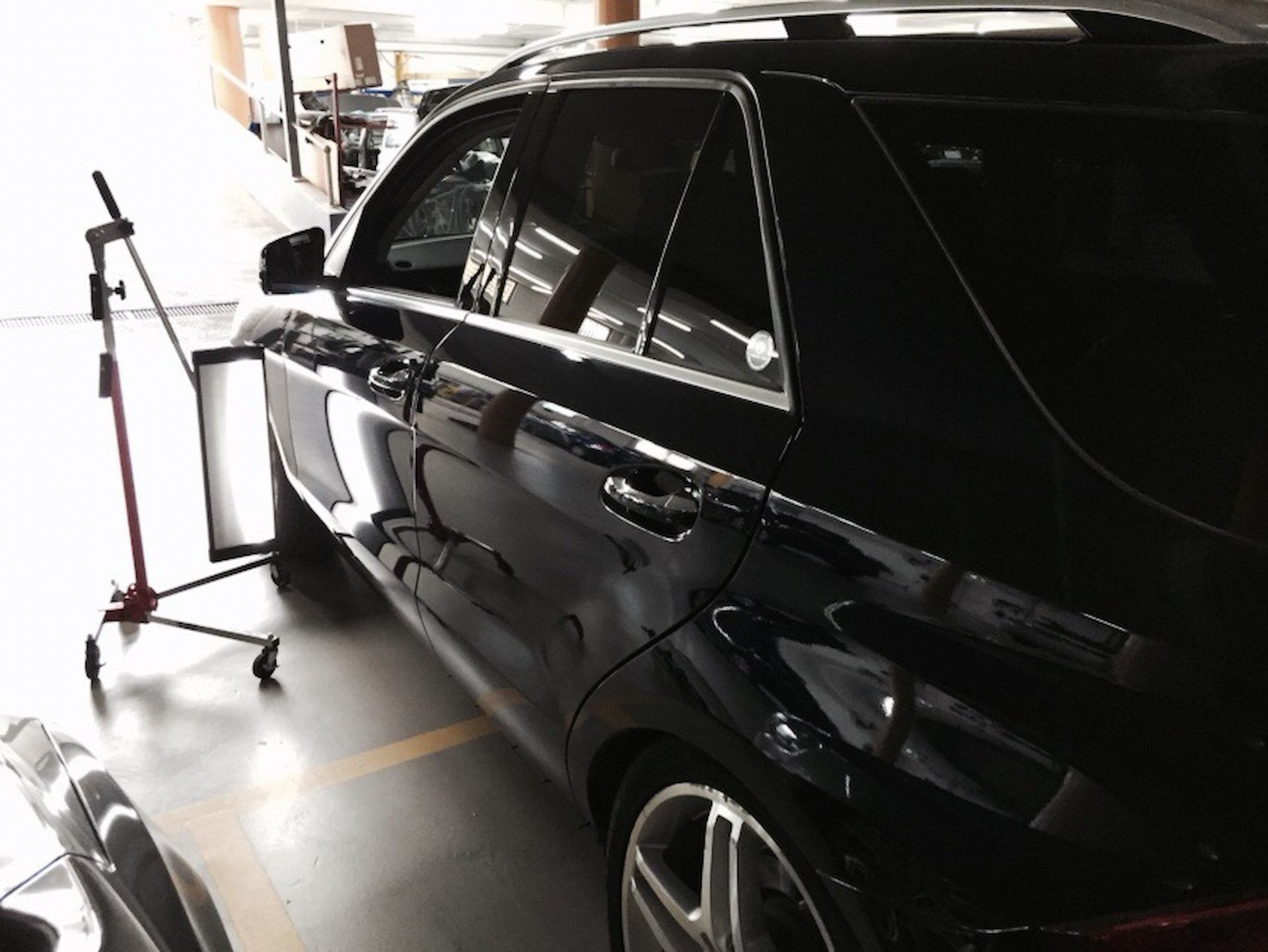 A Black Car is Parked in a Garage Next to a Stand — Rapid Auto Dent In Woy Woy, NSW