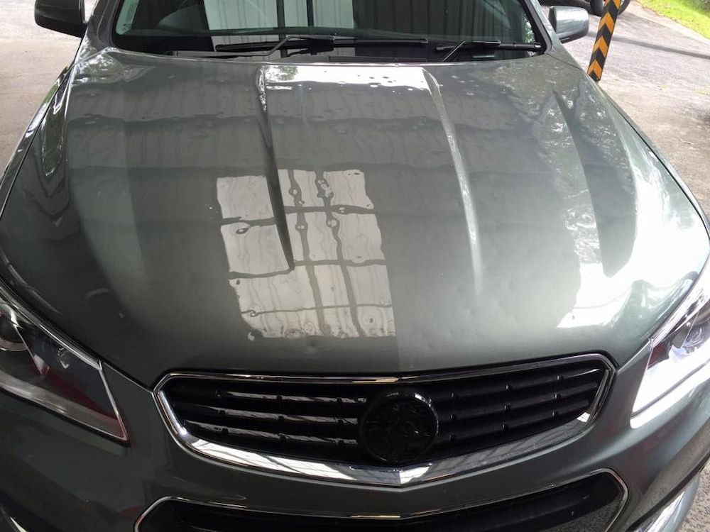 A Gray Car is Parked in a Parking Lot With the Hood Up — Rapid Auto Dent In West Gosford, NSW