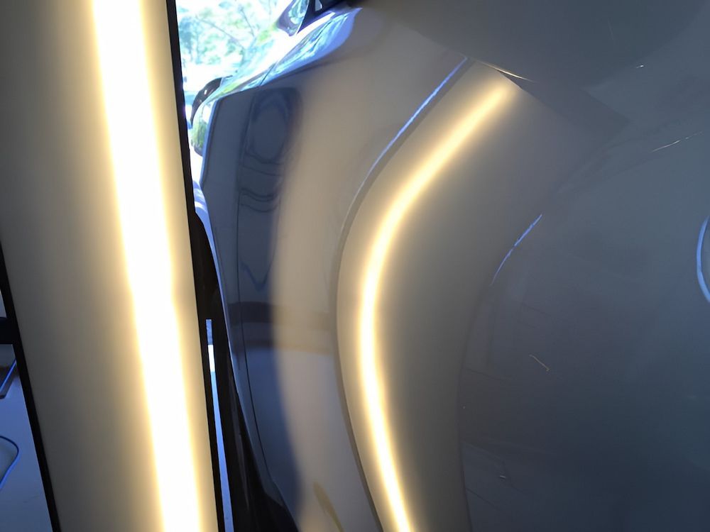 A Close Up Of A White Car With A Light Shining On It — Rapid Auto Dent In Wyong, NSW