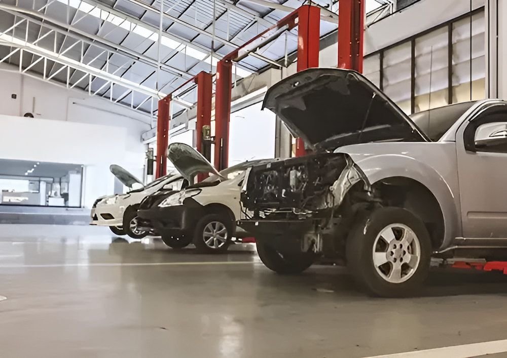 A Row of Cars Are Parked in a Garage With Their Hoods Open — Rapid Auto Dent In Ettalong, NSW