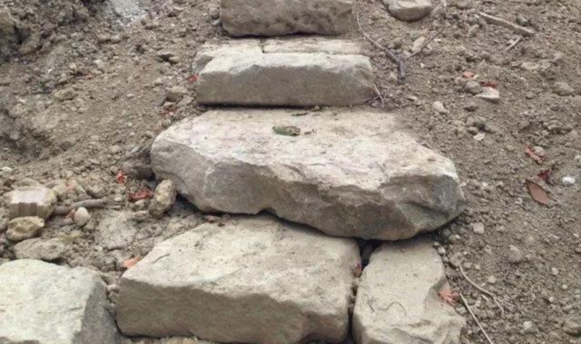 Rough stone steps built into a dirt slope outdoors