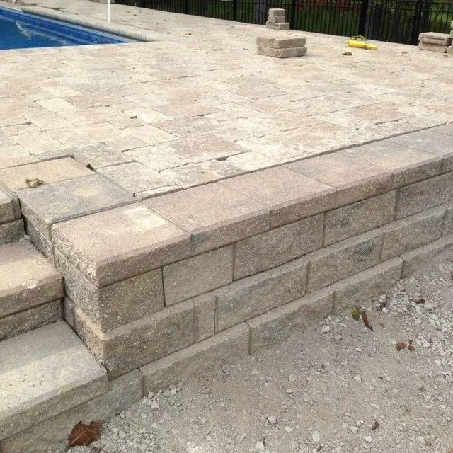 Stone pool deck with a stepped retaining wall and gravel edge