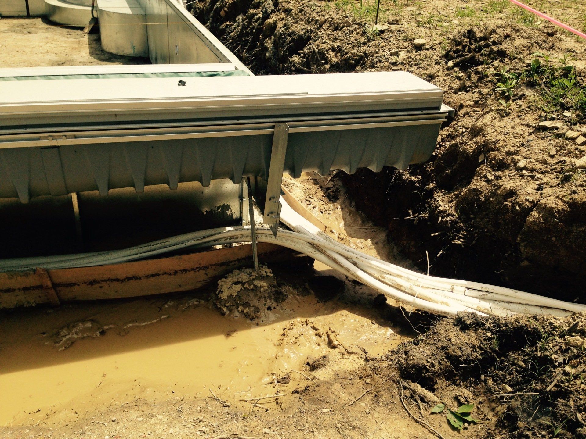Collapsed dock edge over muddy water and eroded shoreline