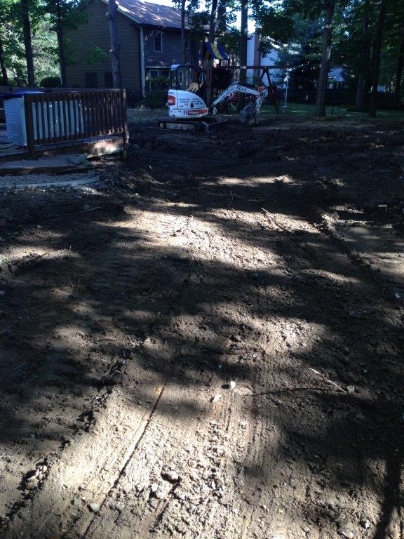 Sunlit dirt driveway with shadows, a house in back, and a white utility truck near the porch.