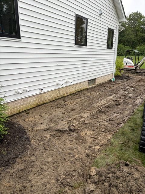 Mud and dirt beside white house after excavation work