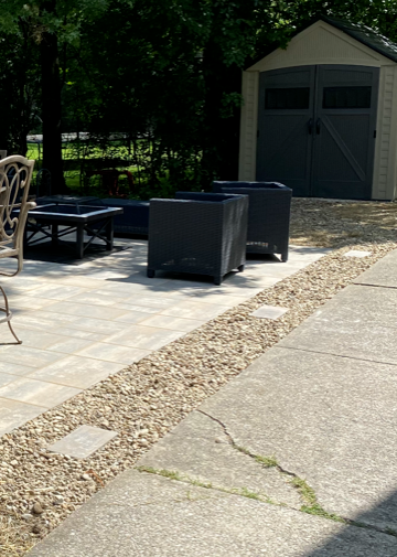 Patio with outdoor furniture and a gray storage shed in the background
